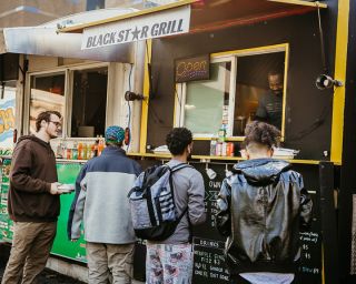 people lined up in front of food carts