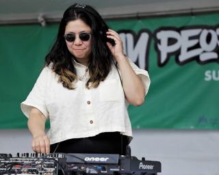 a DJ adjusts a knob on a mixer