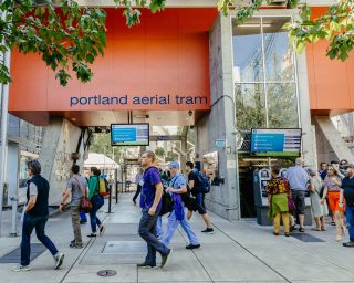 People walk by a transit station for the  aerial tram