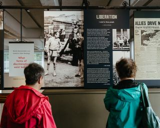 two people read an informational placard at the holocaust museum