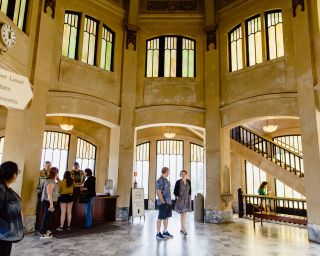 the interior entrance of the vista house, featuring tall ceilings and visitors milling about