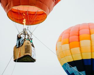 a man controlling the fire in a hot air balloon