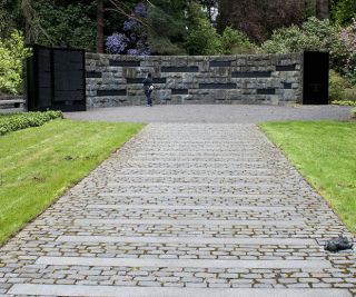 a person stands in front of a memorial made of stone bricks