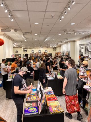 people browsing through shelves of comics inside a store