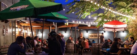 outdoor tables at a pub full of customers at night