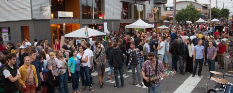 crowd gathered around a street musician as he performs at Last Thursday art walk