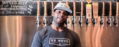 A man standing in front of a row of beer taps