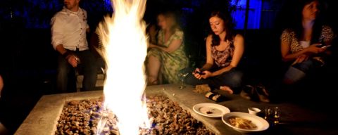 people sitting around a fire pit at night