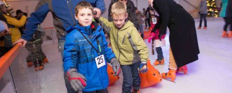 two children and a man on ice skates