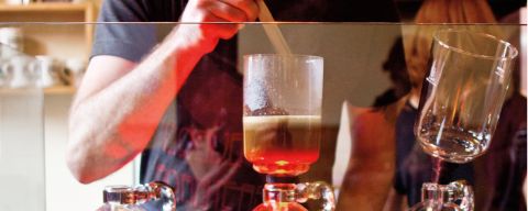 A barista creates a pour-over coffee drink