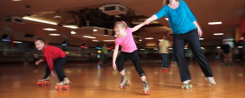 a family roller skating at Oaks Amusement Park