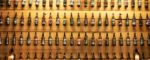 beer bottles displayed in lines against a wall