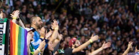 a group of Portland Timbers football fans celebrate at a game