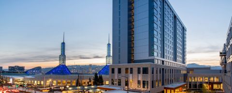 Exterior view of the Hyatt Regency Portland with the twin spires of the Oregon Convention Center in the background