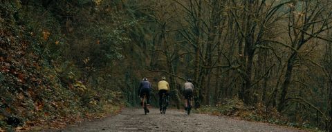 three cyclists ride on a muddy gravel path in Forest Park