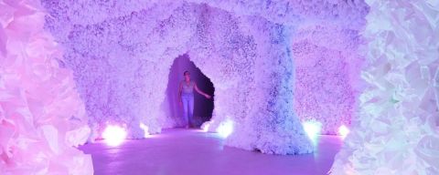 A person explores brightly lit, highly textured cave-like structure.