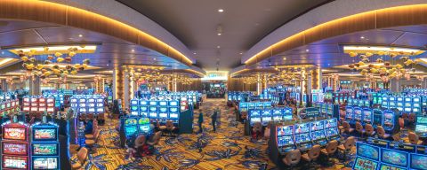 interior of a casino showing the gaming room with multiple rows of slot machines