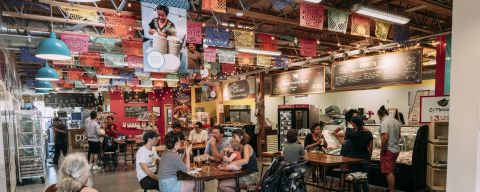 groups of people at tables in an indoor market dining area