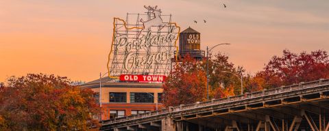 a sign reading portland, oregon against a fall sky