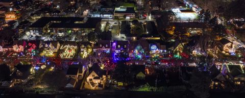 aerial view of colorful holiday lights adorning houses on a street
