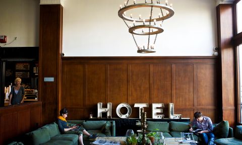 two people seated on a couch in a hotel lobby