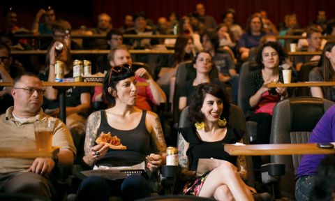 movie goers enjoy pizza and beer