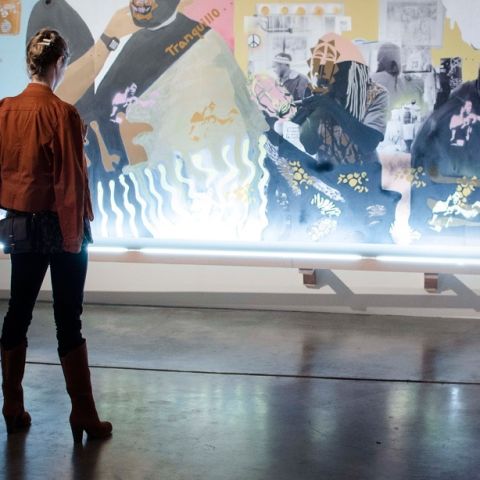 a person standing in front of at a large piece of art