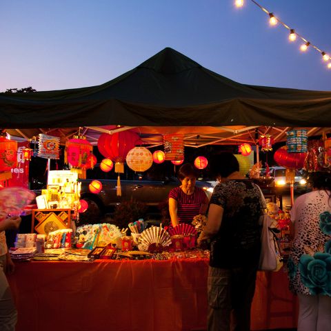 person selling products under a tent at an outdoor market