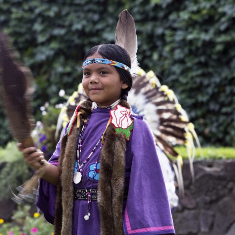 a girl dressed in Native American dance regalia
