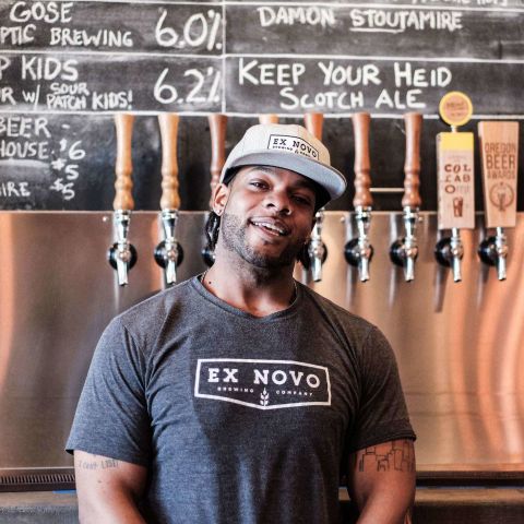 A man standing in front of a row of beer taps