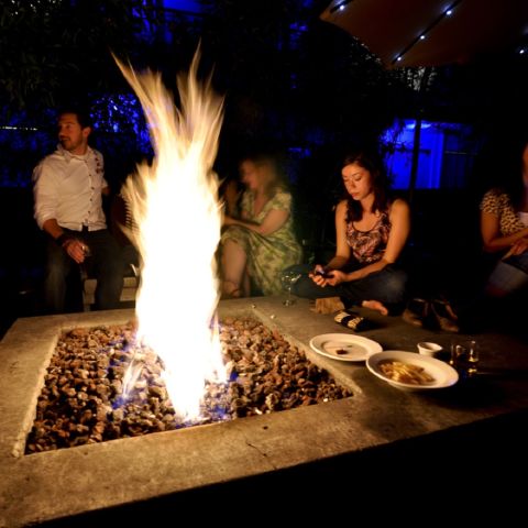 people sitting around a fire pit at night