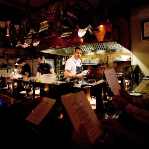 a chef stands in a small open kitchen