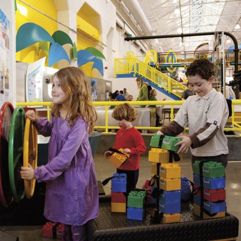 children playing with large interactive toys in an indoor play area at OMSI
