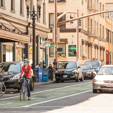 woman riding a bike in a green-painted bike-only lane in downtown