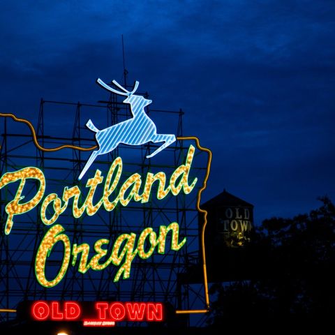 A sign made of light bulbs form the silhouette of the state with a stag jumping over the words Portland Oregon