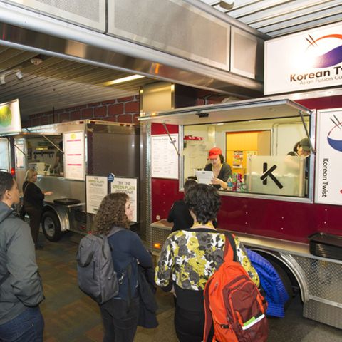 people in line at a food cart in the Portland Airport
