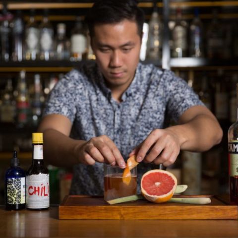 a bartender prepares a drink made with Negroni