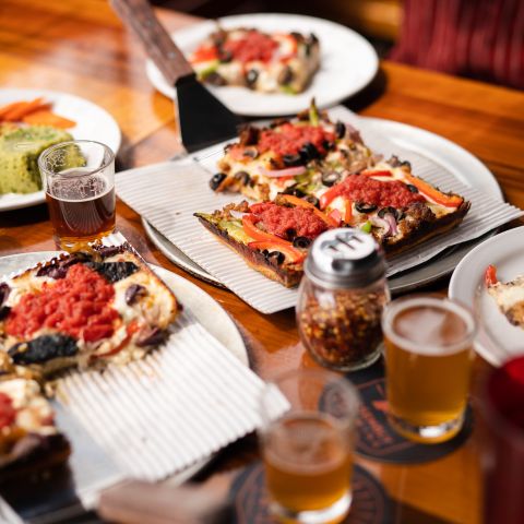 Square pizzas and beer samplers on a table