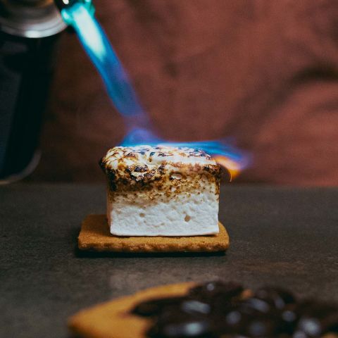 Someone torches a marshmallow smore.
