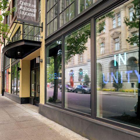 street view of museum entrance with city reflections on the windows