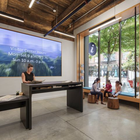 People sitting in the entryway at the Portland Visitor Center, reading brochures and socializing.