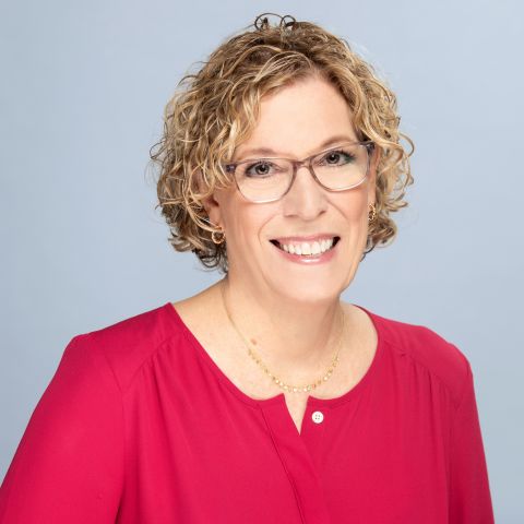 Woman with bright red blouse headshot