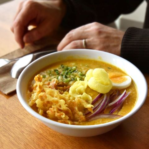 a close-up of a vibrant bowl of tempting Burmese noodle soup