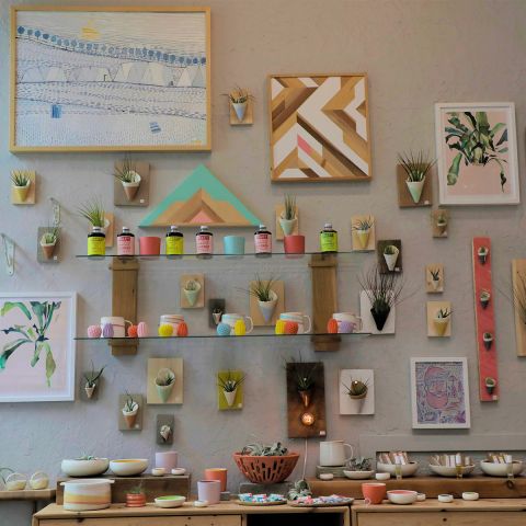 a wall display of ceramic arts and other crafts inside a ceramics studio.