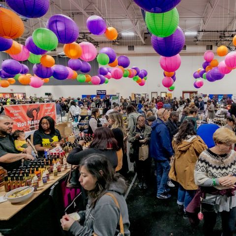 people shopping for arts and crafts in a bright space with colorful paper lights hanging from the ceiling