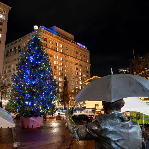 Umbrella man statue overlooking Christmas tree in Pioneer Square