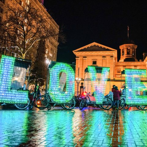 on a dark night in the city large lettering illuminated in aquamarine spell LOVE