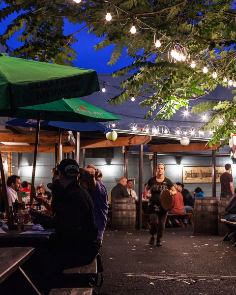 outdoor tables at a pub full of customers at night