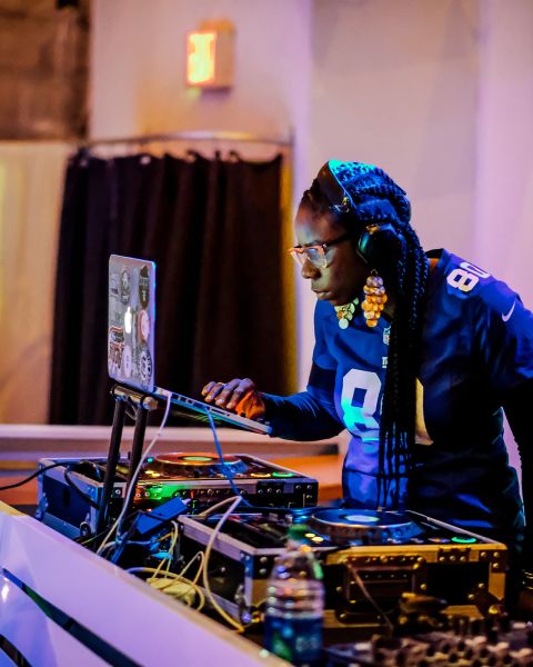 a music dj looking at a laptop connected to electronic turntables