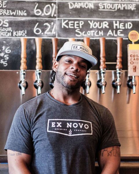 A man standing in front of a row of beer taps